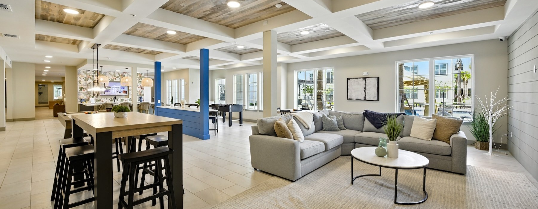 a clubroom with a couch, tables and chairs