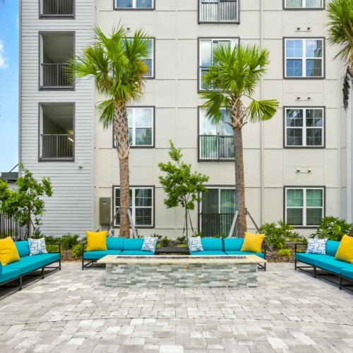 a courtyard with a fire pit and couches